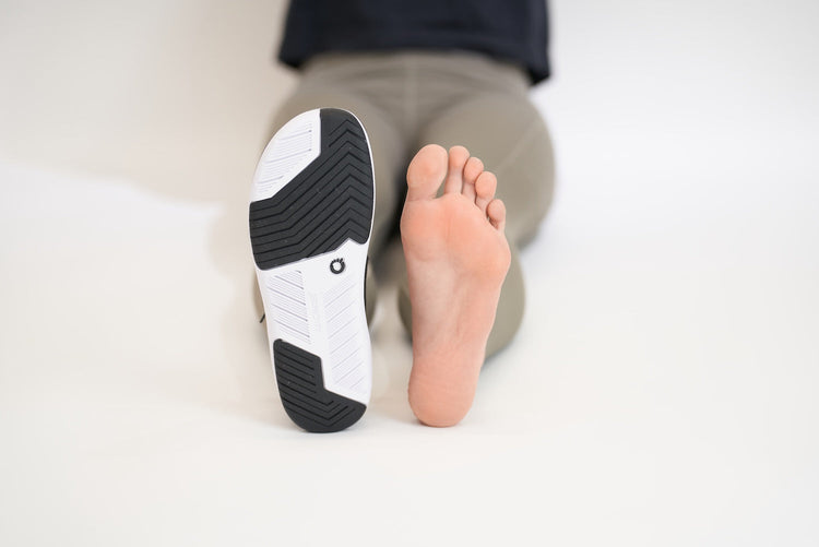 One foot with shoe, one bare foot