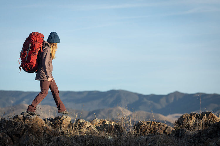 women walking on mountain ridge with camping pack